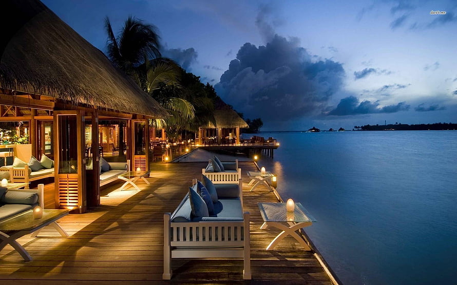 Luxury Overwater Bungalow at Dusk with Palm Trees and Calm Ocean View HD wallpaper