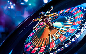 Close-Up of a Spinning Casino Roulette Wheel with Vibrant Neon Lighting HD wallpaper