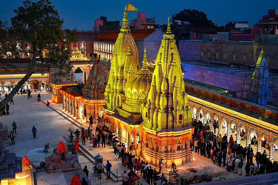 Kashi Vishwanath Temple at Dusk with Golden Shikharas and Devotees HD wallpaper