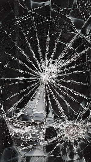 Shattered Smartphone Screen with Radiating Cracks on Dark Background HD phone wallpaper