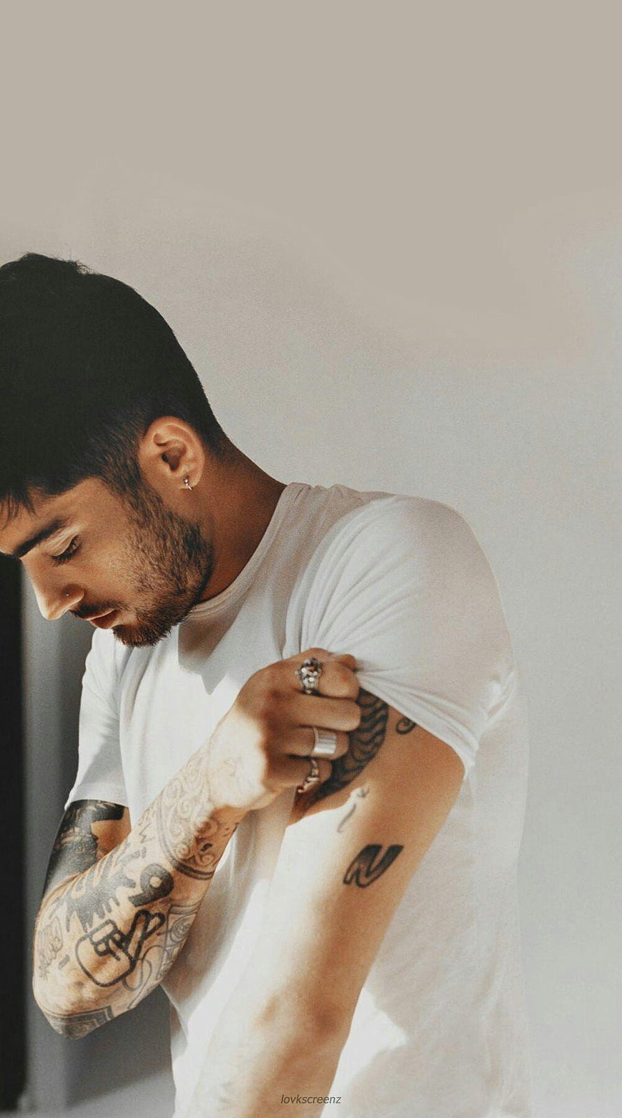 Zayn Malik in a white t-shirt with visible arm tattoos and rings HD phone wallpaper