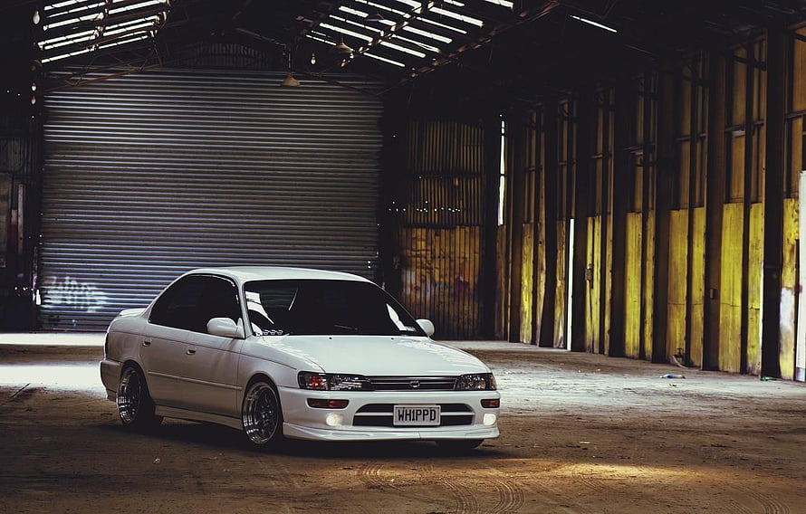 White Toyota Corolla AE100 Sedan Parked in Industrial Warehouse HD wallpaper