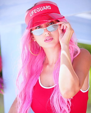Nora Fatehi in a red lifeguard visor and swimsuit with long pink hair and white sunglasses HD phone wallpaper
