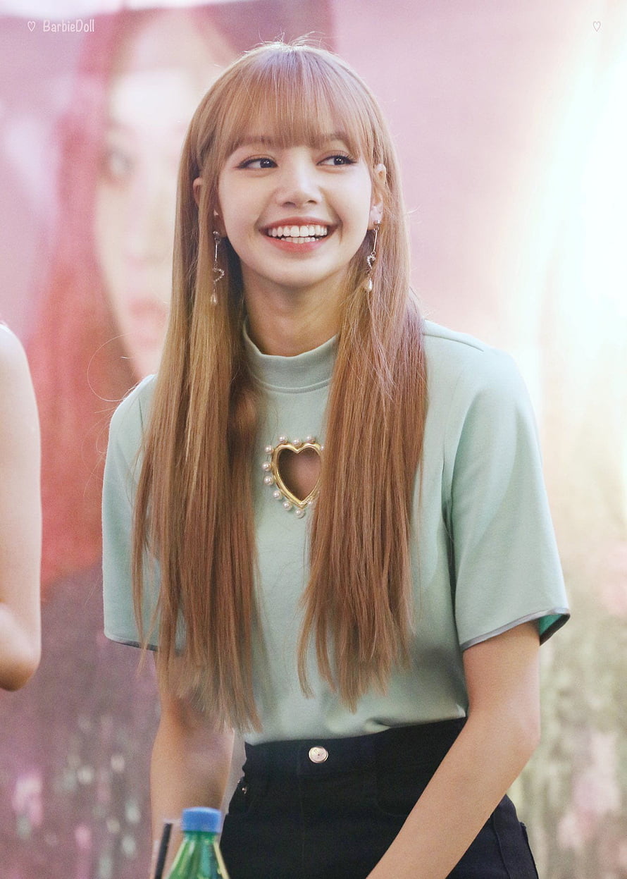 Lisa from BLACKPINK smiling in a mint green top with a heart cutout and long blonde hair HD phone wallpaper