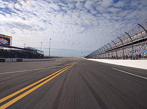 Empty NASCAR Race Track With Grandstands And Scattered Clouds Under A Blue Sky HD wallpaper