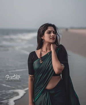 Swasika Vijay in a green sari on a misty beach with ocean waves HD phone wallpaper