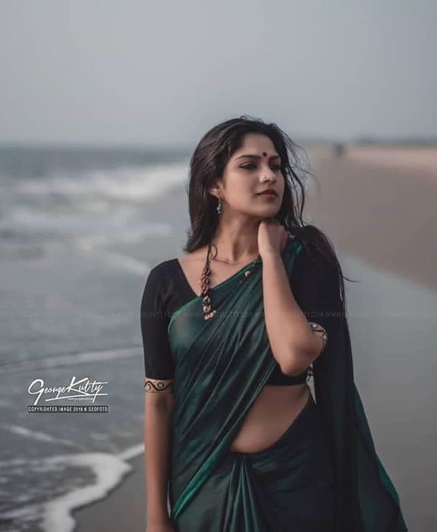 Swasika Vijay in a green sari on a misty beach with ocean waves HD phone wallpaper