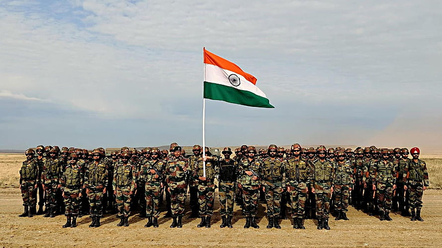 Indian Army soldiers in formation with national flag in desert landscape HD wallpaper