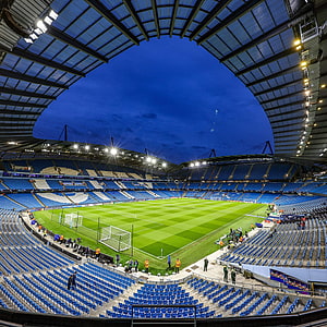 Etihad Stadium Interior at Dusk with Floodlights and Blue Seating HD phone wallpaper