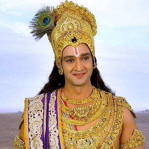 Saurabh Jain as Lord Krishna in ornate golden crown and peacock feather headdress HD phone wallpaper