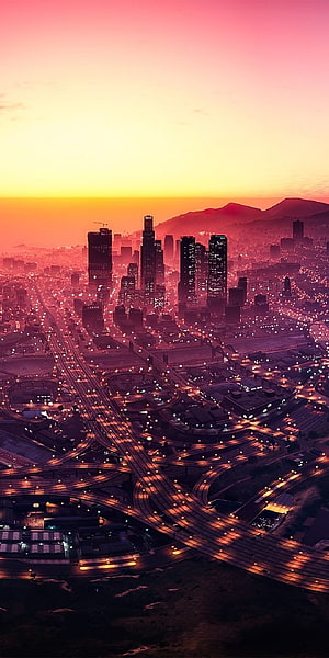 Los Santos Skyline at Dusk in GTA V with Glowing Highway Interchanges and Vibrant Sunset Sky HD phone wallpaper