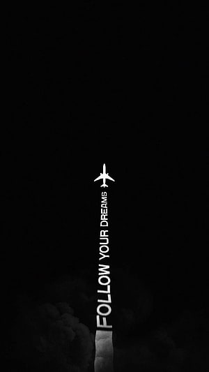 Minimalist Black Wallpaper with White Airplane Icon and Vertical Follow Your Dreams Text HD phone wallpaper