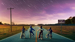 Stranger Things Four Boys Riding Bikes on Road Under Starry Sky HD wallpaper