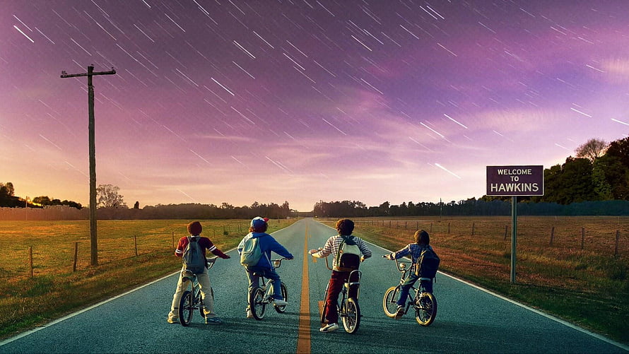 Stranger Things Four Boys Riding Bikes on Road Under Starry Sky HD wallpaper