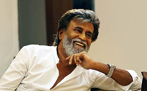 Rajinikanth smiling in a white shirt with a silver beard and wristwatch HD wallpaper