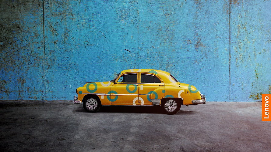 Vintage Yellow Car with Polka Dots Parked Against a Weathered Blue Wall HD wallpaper