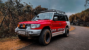 Red Mitsubishi Pajero SFX Off-Road SUV on Mountain Road HD wallpaper