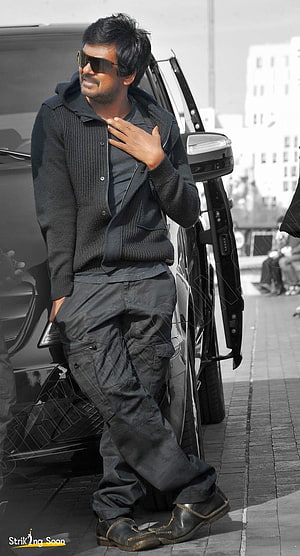 Puri Jagannadh in Black Knit Cardigan and Cargo Pants Leaning Against SUV HD phone wallpaper