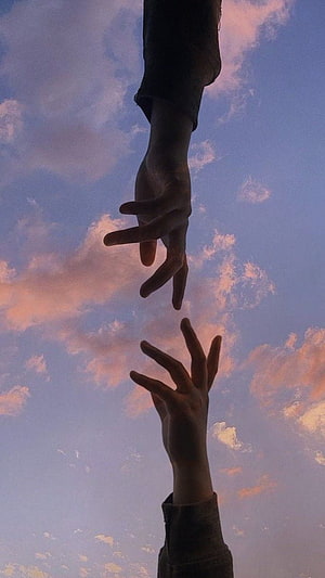 Two Silhouetted Hands Reaching Toward Each Other Against a Soft Sunset Sky HD phone wallpaper