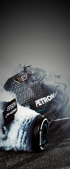 Mercedes Petronas Formula 1 Car Drifting Through Tire Smoke on Wet Track HD phone wallpaper