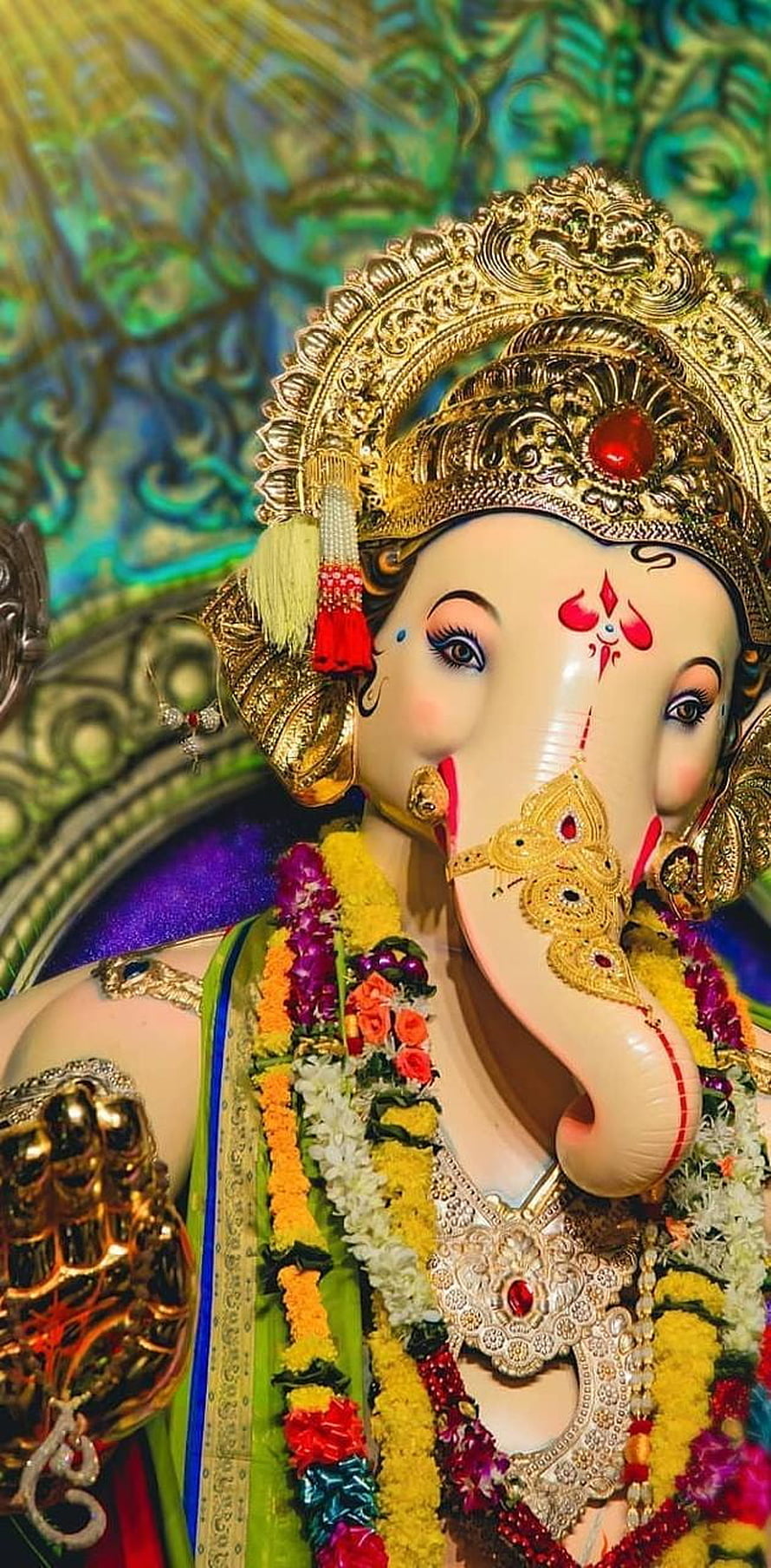 Ornate Chintamani Ganpati Murti Adorned With Gold Crown And Vibrant Flower Garlands HD phone wallpaper