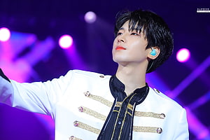 Wonwoo from ATEEZ performing on stage in a white military-style jacket with gold accents HD wallpaper