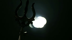 Silhouetted Trishul Trident Against Bright Moonlight in Dark Night Sky HD wallpaper