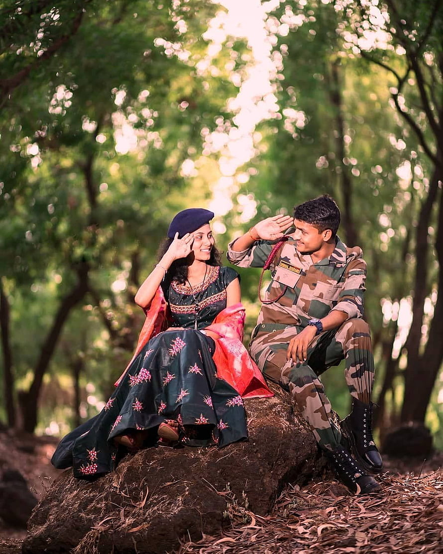 Indian Army couple in camouflage and traditional dress sitting on a rock in a forest HD phone wallpaper