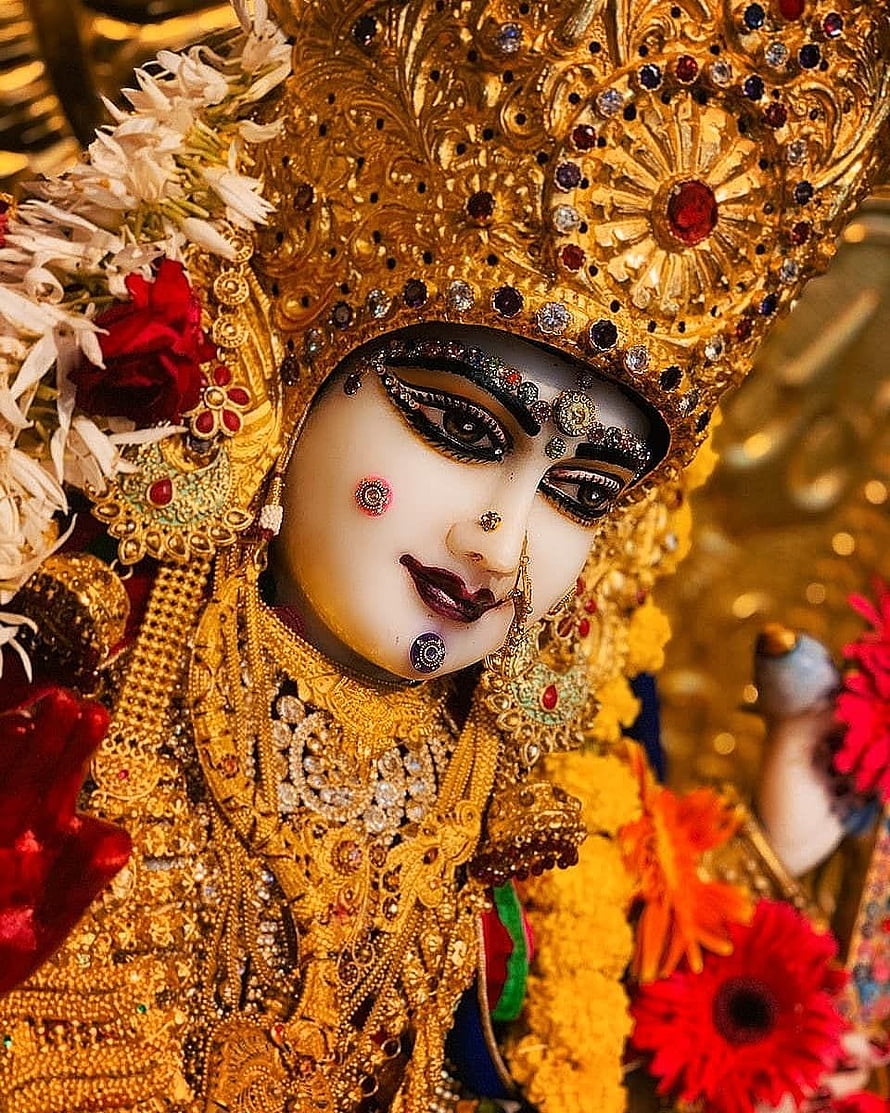 Meldi Maa Malataj ornate golden deity statue adorned with intricate jewelry and vibrant floral garlands HD phone wallpaper