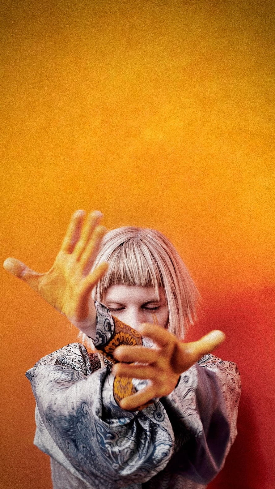Aksnes Aurora Singer Portrait With Dramatic Hand Gesture Against Warm Orange Gradient Background HD phone wallpaper