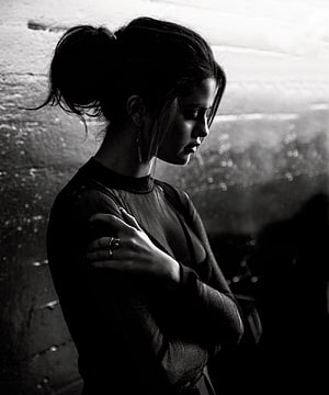 Selena Gomez in a moody black and white portrait with arms crossed HD phone wallpaper
