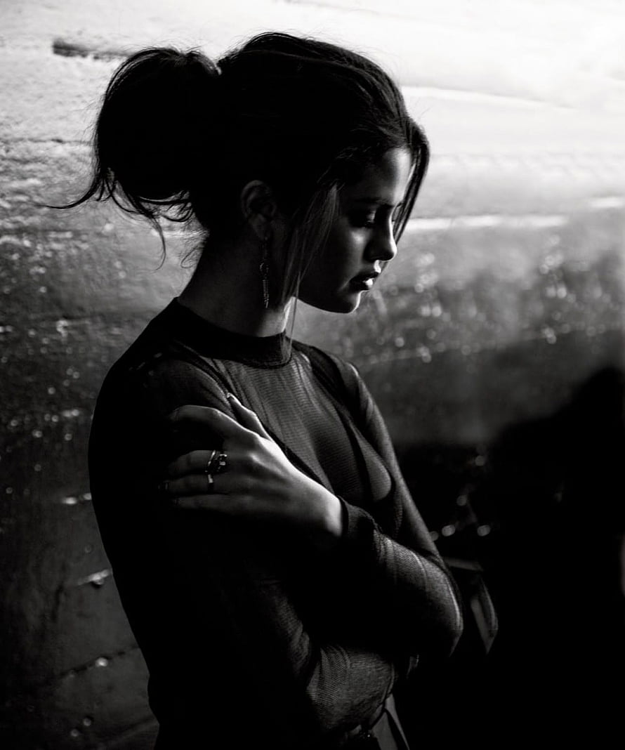 Selena Gomez in a moody black and white portrait with arms crossed HD phone wallpaper