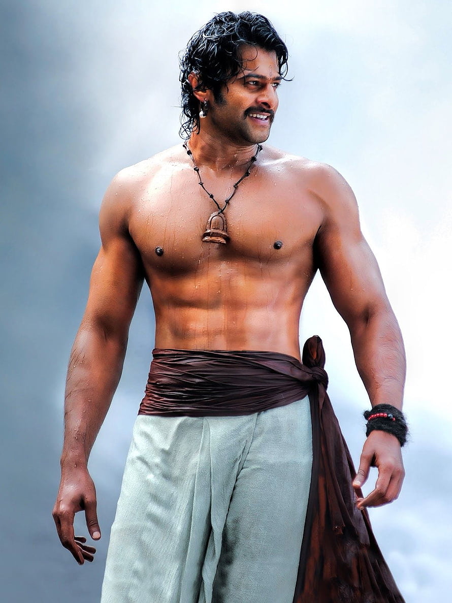 Prabhas in a shirtless warrior pose wearing a brown sash and light trousers against a misty backdrop HD phone wallpaper