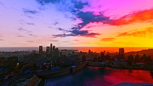 GTA V Los Santos Cityscape at Sunset with Vibrant Sky and Water Reflection HD wallpaper