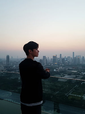 Cha Eun Woo on a rooftop terrace overlooking a city skyline at dusk HD phone wallpaper