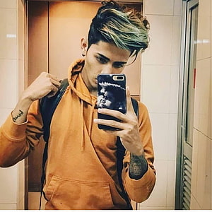 Danish Zehen mirror selfie in orange hoodie with green-tipped hair and backpack HD phone wallpaper