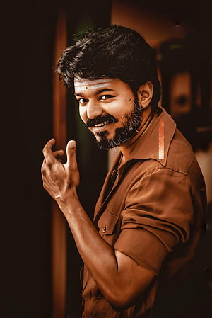Vijay in Mersal and Master film stills with warm cinematic lighting and expressive pose HD phone wallpaper