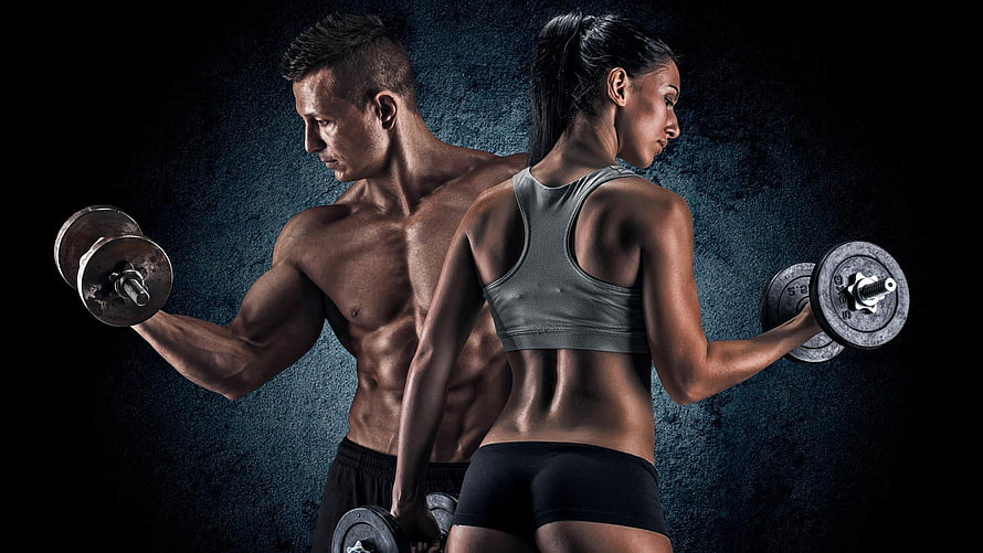 Muscular Man And Woman Lifting Dumbbells In Dramatic Gym Setting HD wallpaper