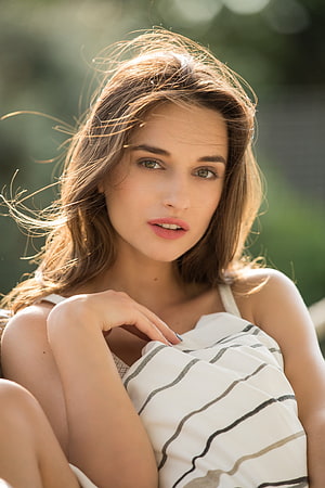 Gloria Sol Portrait: Windblown Hair and Sunlit Green Eyes in a Striped Top HD phone wallpaper