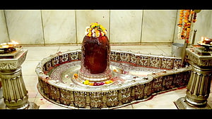 Mahakaleshwar Jyotirlinga shrine adorned with fresh flower garlands and ornate silver ritual vessels HD wallpaper