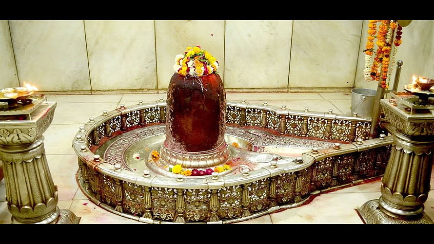 Mahakaleshwar Jyotirlinga shrine adorned with fresh flower garlands and ornate silver ritual vessels HD wallpaper