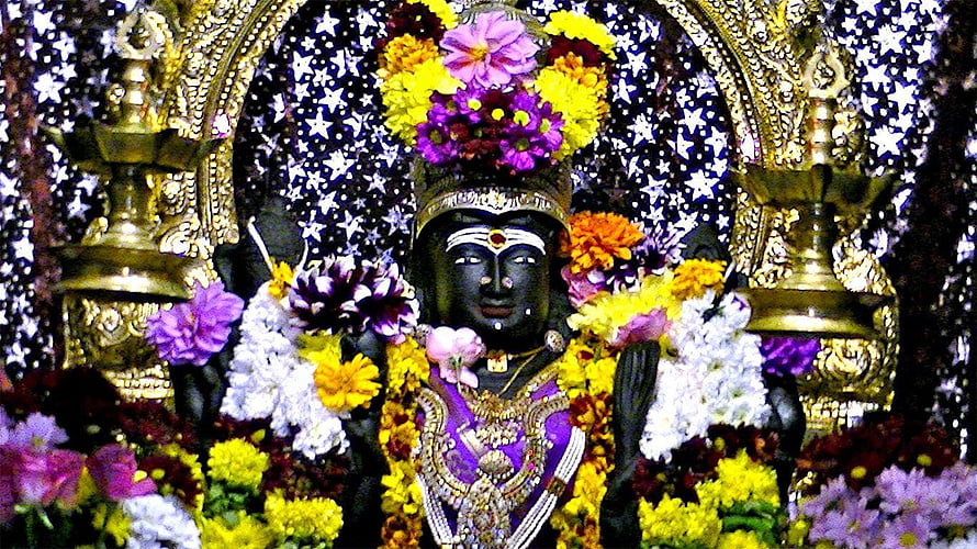 Ornate Amman Deity Statue Adorned With Vibrant Flower Garlands And Gold Jewelry HD wallpaper