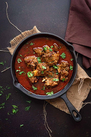 Slow-Cooked Mutton Curry in Cast Iron Skillet with Fresh Herbs HD phone wallpaper