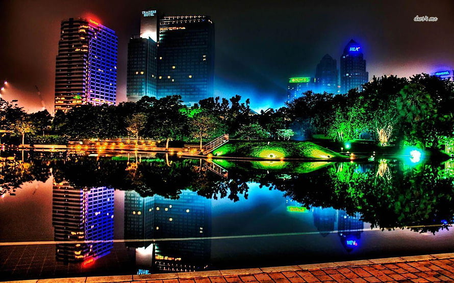Vibrant Night Cityscape with Illuminated Skyscrapers and Lake Reflections HD wallpaper