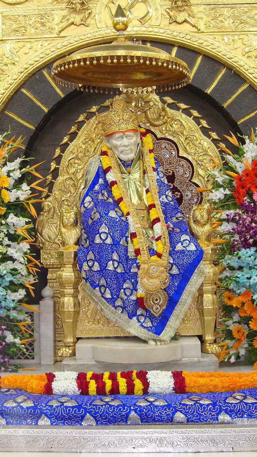 Sai Baba Temple Idol Adorned in Blue Silk and Marigold Garlands HD phone wallpaper