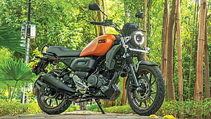 Yamaha FZ-X Motorcycle in Orange and Black Parked in a Lush Green Forest Setting HD wallpaper