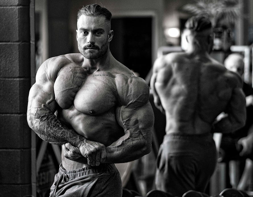 Chris Bumstead Bodybuilder Posing in Black and White Gym Portrait HD wallpaper