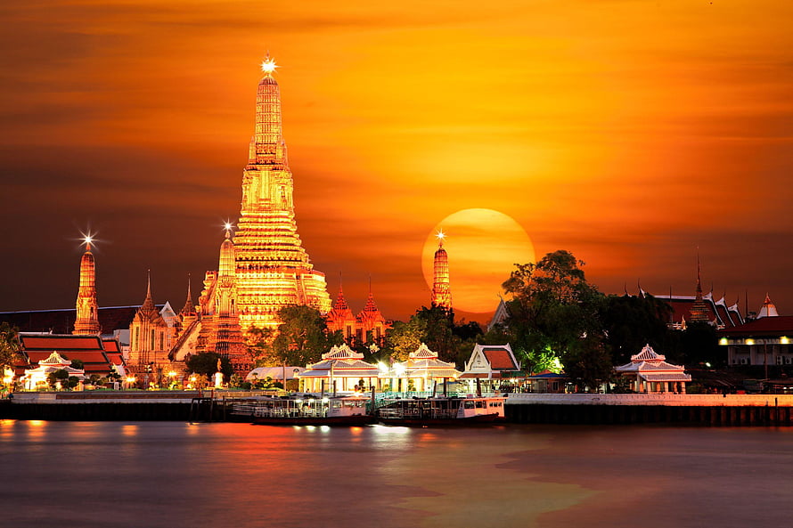Wat Arun Temple Illuminated at Sunset Along the Chao Phraya River in Bangkok, Thailand HD wallpaper