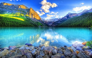Turquoise Mountain Lake with Rocky Shoreline and Forested Peaks HD wallpaper