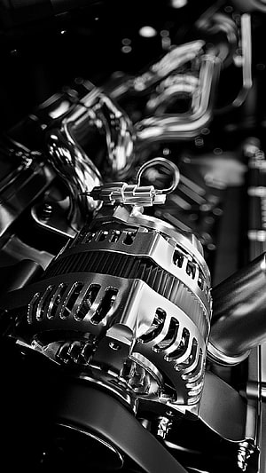 Black and White Close-Up of a Polished Car Alternator and Engine Bay Components HD phone wallpaper